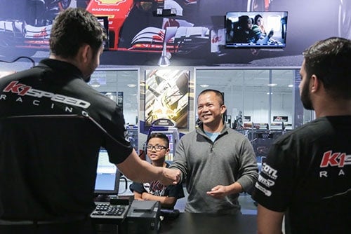cashier hands a membership card to a customer at k1 speed